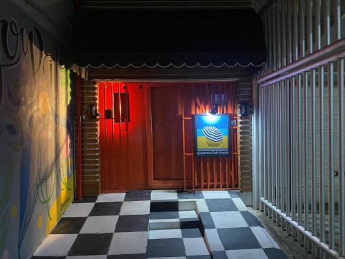 a hallway with a red door and a checkered floor at Ipanema Club Hostel in Rio de Janeiro