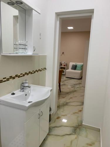 a white bathroom with a sink and a mirror at Lilly in Palić