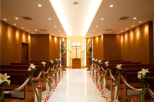 a row of pews in a church with flowers at Bellino Hotel Ichinoseki in Ichinoseki