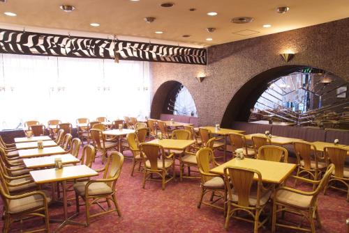 uma sala de jantar cheia de mesas e cadeiras em Hotel Matsunoka Ichinoseki em Ichinoseki