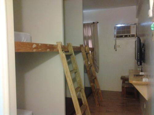 duas escadas de madeira numa cozinha com um frigorífico em Herbaceous-Inn em Nanwan