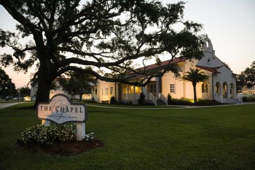a building with a sign in front of a house at Centennial Plaza Resort Gulfport in Gulfport