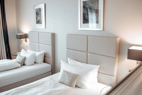 a hotel room with a bed with white pillows at Clostermanns Hof in Niederkassel