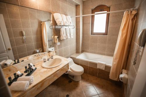 a bathroom with a sink and a toilet and a tub at Hotel Hacienda Puno Centro Histórico in Puno