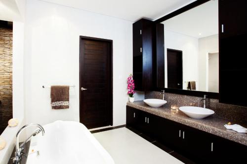 baño con 2 lavabos y espejo grande en Villa Penelopy, en Seminyak