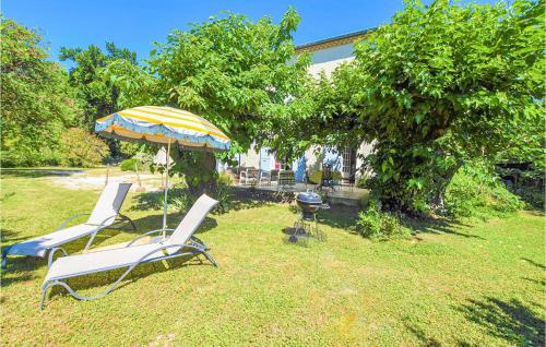 2 chaises et un parasol dans la cour dans l'établissement Amazing Apartment In Avignon With Wifi, à Avignon