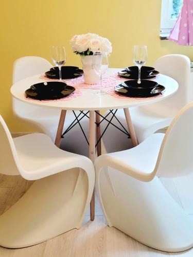 a table and chairs with wine glasses and flowers on it at Apartamenty Niebo in Kowary