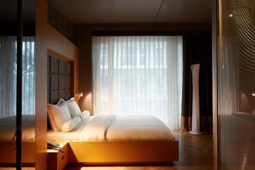 a bedroom with a bed and a large window at Amadi Park Hotel in Amsterdam