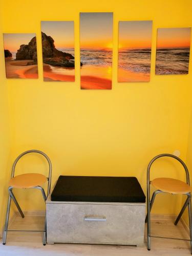 a room with a yellow wall with a bed and two chairs at Apartamenty Niebo in Kowary