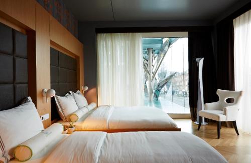 a bedroom with two beds and a large window at Amadi Park Hotel in Amsterdam