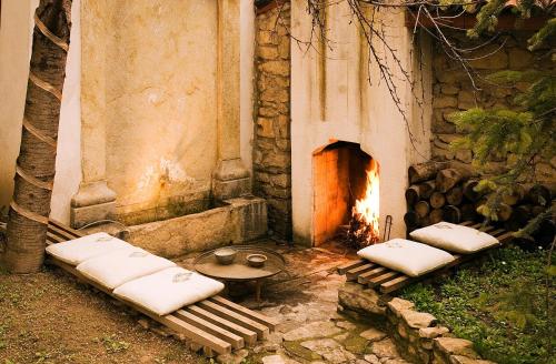 a room with a fireplace with pillows and a table at Gulevi Safranbolu in Safranbolu