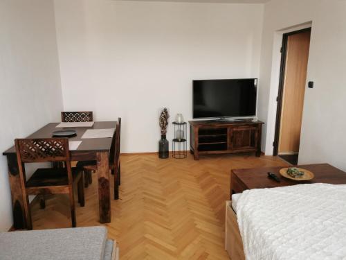 a living room with a table and a television at Slaný - byt 1+1 in Slaný