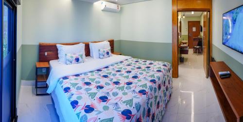 a bedroom with a large bed with a colorful bedspread at Pousada Flores do Carmo in Pirenópolis