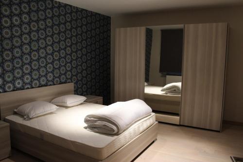 sypialnia z łóżkiem i dużym lustrem w obiekcie Golden Tulip w Ostendzie