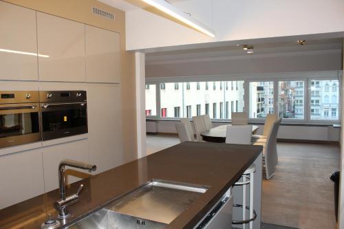 a kitchen with a sink and a table with chairs at Golden Tulip in Ostend