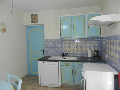 a kitchen with blue cabinets and a sink at L'Oliveraie in Draguignan