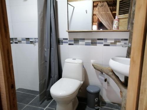 a bathroom with a toilet and a sink at Palmar del viento cabaña frente al mar in Moñitos