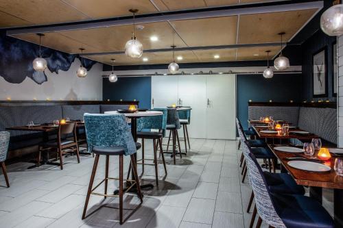 a restaurant with wooden tables and blue chairs at voco St Augustine Historic Area by IHG in St. Augustine