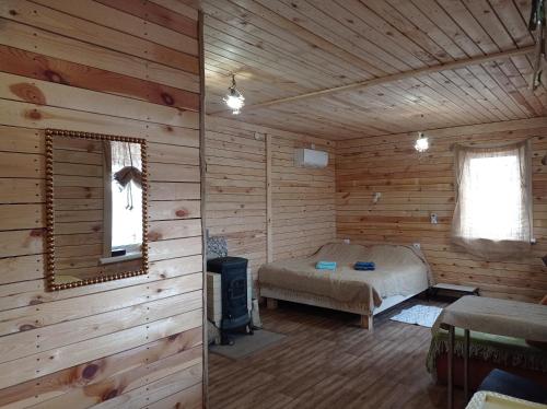 una camera con un letto in una baita di tronchi di Cuba a Bolʼshaya Balabanka