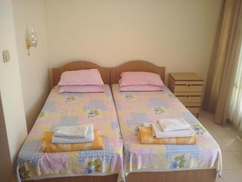 a bedroom with a bed with two towels on it at Guest House Preslav in Nesebar