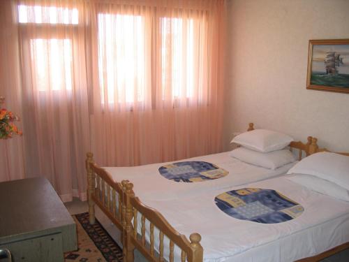 a bedroom with two twin beds and a table at Guest House Preslav in Nesebar