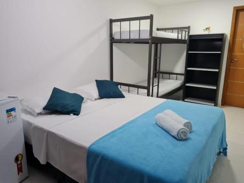 a bedroom with a bed with a blue blanket and bunk beds at Suites Golfo in Abraão
