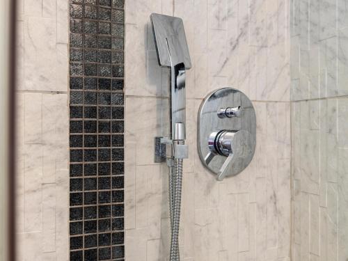 a shower with a shower head on a wall at Desana Studio in Turin