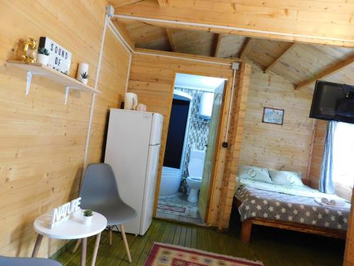 uma pequena sala com um frigorífico e um quarto em Sound of Nature Tismana em Tismana