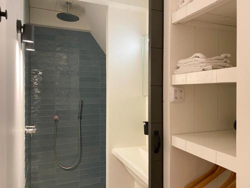 een badkamer met een douche met blauwe tegels bij B&B 't Gasthuysje in Dokkum