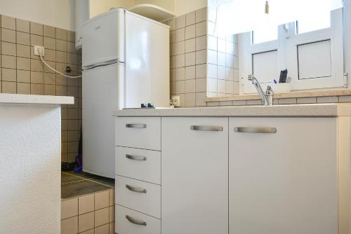 een keuken met witte kasten en een koelkast bij City Centre Apartments SPLIT OLD TOWN in Split
