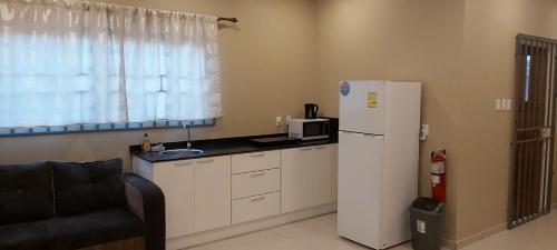 a kitchen with a white refrigerator and a microwave at Waterland Suites in Paramaribo