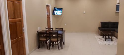 a dining room with a table and chairs and a couch at Waterland Suites in Paramaribo