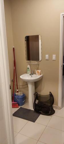 a bathroom with a sink and a tv on the wall at Waterland Suites in Paramaribo