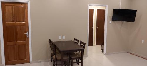 a dining room with a table and chairs and a television at Waterland Suites in Paramaribo