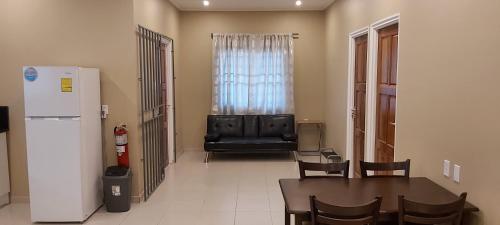a living room with a table and a refrigerator at Waterland Suites in Paramaribo