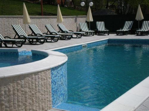 a swimming pool with chaise lounge chairs and a row at Hotel Perfect in Yamna