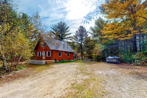 a red house in the middle of a dirt road at Alpen Suite in Ossippee in Ossipee