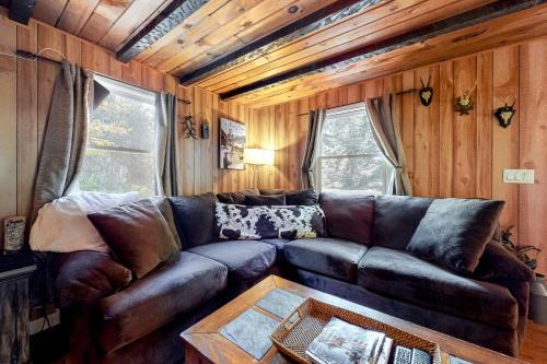 a living room with a leather couch and a table at Alpen Suite in Ossippee in Ossipee