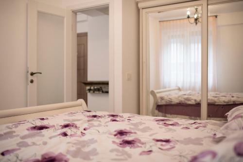 Un dormitorio con una cama con flores púrpuras. en Căsuța din Copou en Iaşi