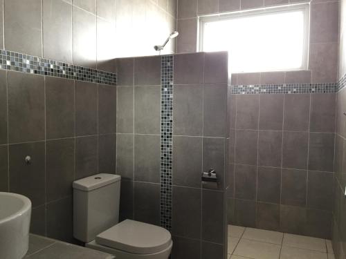 a bathroom with a toilet and a sink and a shower at MASKANI Villa in Galu