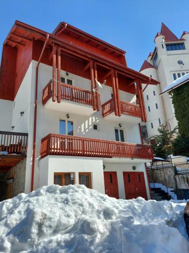 a building with snow in front of it at Apartament Roland in Poiana Brasov