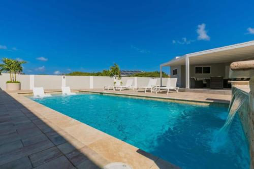 een zwembad voor een huis bij Piece of Paradise in Palm-Eagle Beach