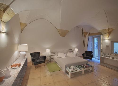 1 dormitorio con 1 cama, 2 sillas y mesa en Corte dei Romiti Apartment, en Lecce