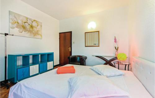 a bedroom with a blue and white bed and a table at Awesome Apartment In Rijeka With Kitchen in Rijeka