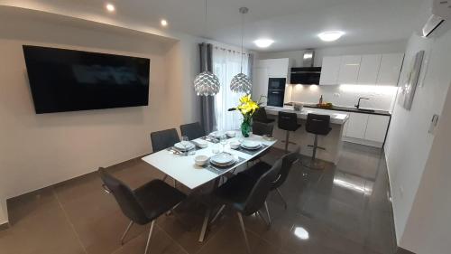 a dining room with a table and chairs and a kitchen at HOLIDAY HVAR lux in Basina