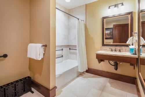 a bathroom with a tub and a shower and a sink at Arrowleaf Lodge - 1 Bed Studio #101A in Park City