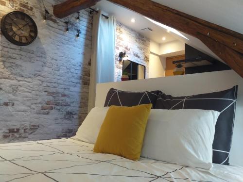 1 dormitorio con 1 cama con reloj en la pared en Les Volets Bleus - Refaits à neuf, deux appartements et un studio, Jardin, en Bourges