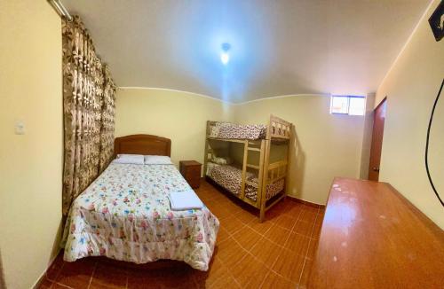 a small bedroom with a bed and a crib at Hospedaje Anais in Pisco