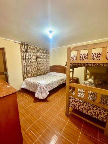 a bedroom with two bunk beds and a wooden floor at Hospedaje Anais in Pisco