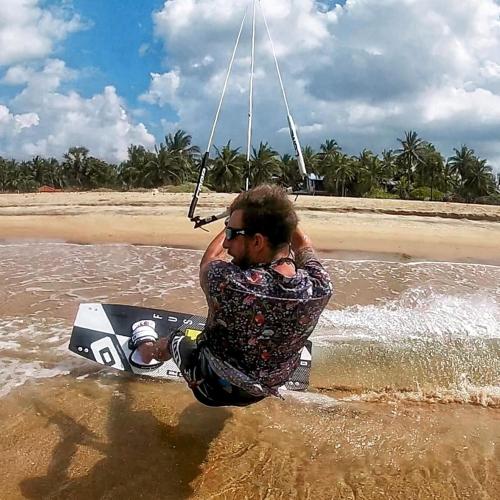a man sitting on a board in the water at Wellé Wadiya Beach Villa in Kalpitiya